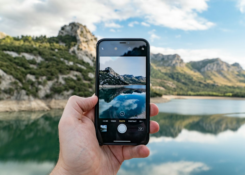 Person holding a smartphone and browsing mobile media